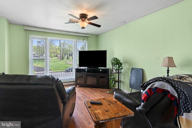 living area featuring ceiling fan, wood finished floors, and a baseboard radiator