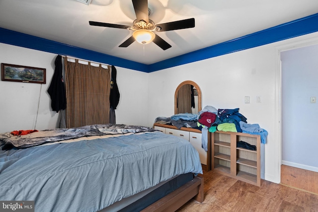 bedroom featuring baseboards, ceiling fan, and wood finished floors