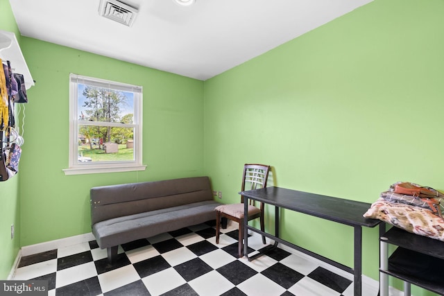 living area featuring tile patterned floors, visible vents, and baseboards