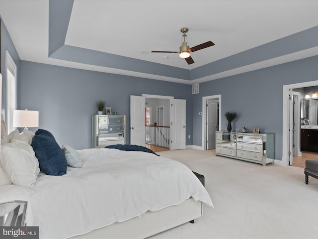 41909 Paddock Gate Pl, Ashburn, VA 20148 - carpeted bedroom featuring a raised ceiling, baseboards, ensuite bath, and ceiling fan