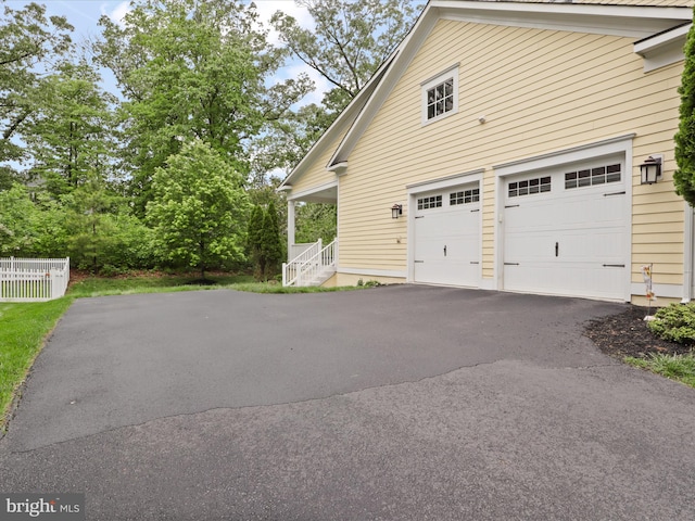 41909 Paddock Gate Pl, Ashburn, VA 20148 - view of side of home with driveway, a garage, and fence