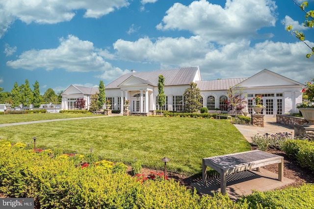 view of front of home with french doors, a patio area, metal roof, and a front yard