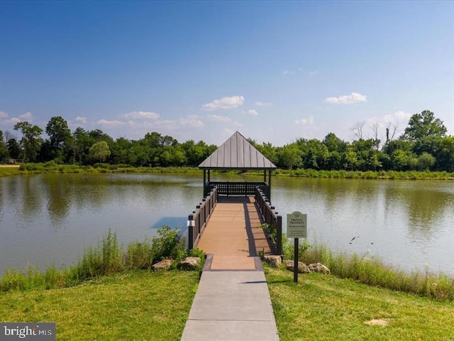 dock area with a lawn, a water view, and a gazebo