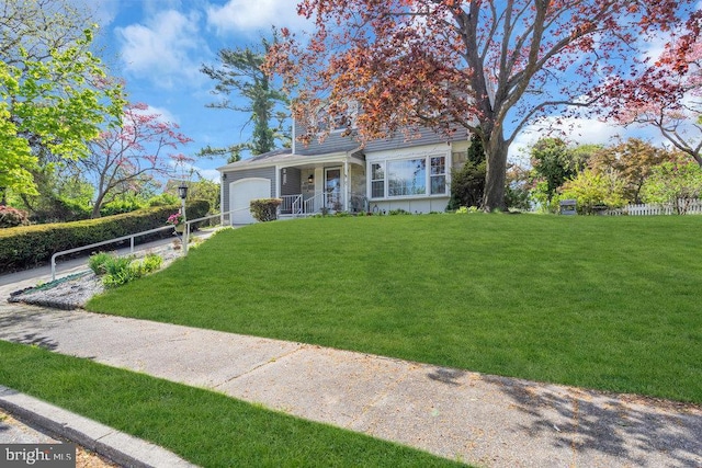 view of front facade with covered porch, an attached garage, fence, and a front lawn