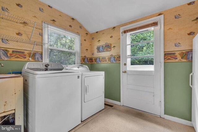 clothes washing area with plenty of natural light, separate washer and dryer, baseboards, and laundry area