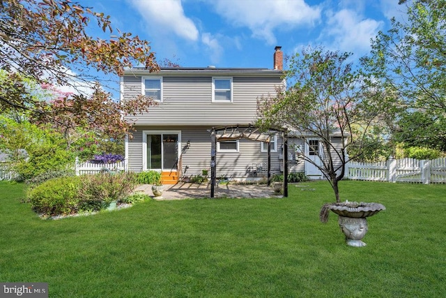 rear view of house featuring fence, a chimney, a lawn, and a patio area
