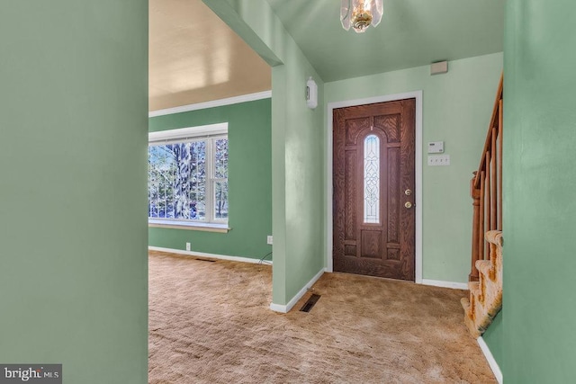 carpeted entryway featuring baseboards, visible vents, and stairway