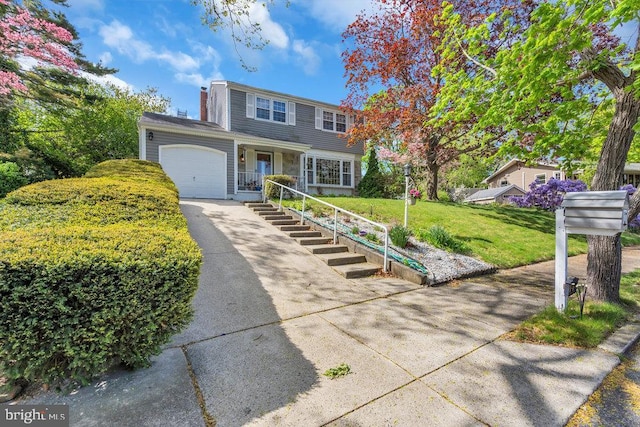 view of front of home featuring driveway, a front yard, and a garage