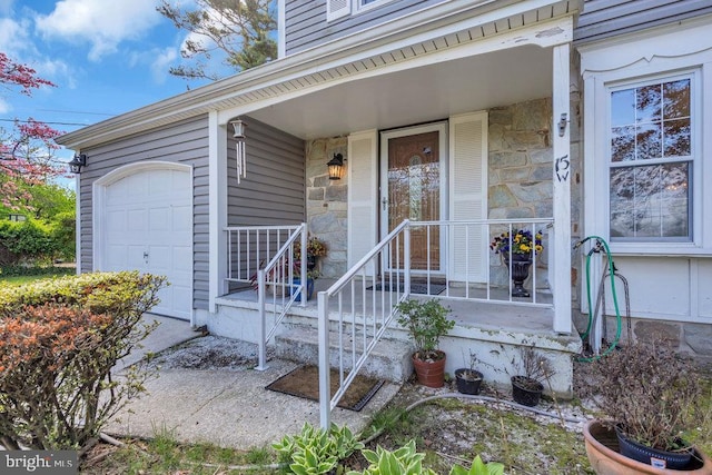 property entrance with covered porch and stone siding