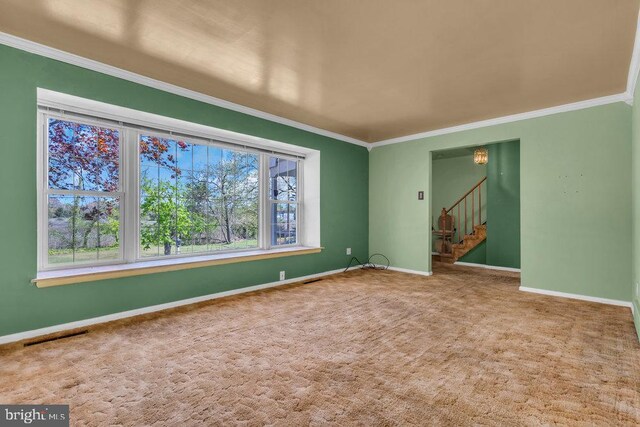 carpeted empty room with crown molding, stairs, baseboards, and visible vents