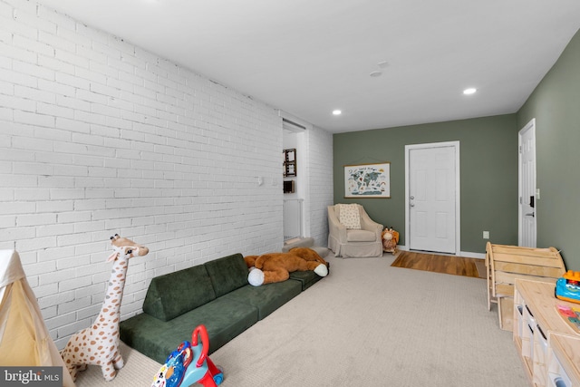 rec room with baseboards, carpet flooring, recessed lighting, and brick wall