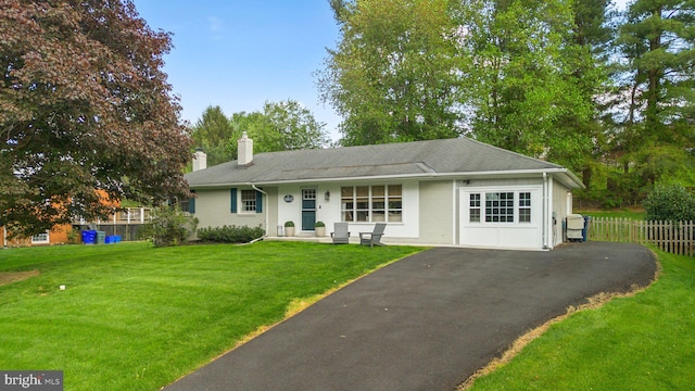 single story home with aphalt driveway, fence, a front yard, and a chimney