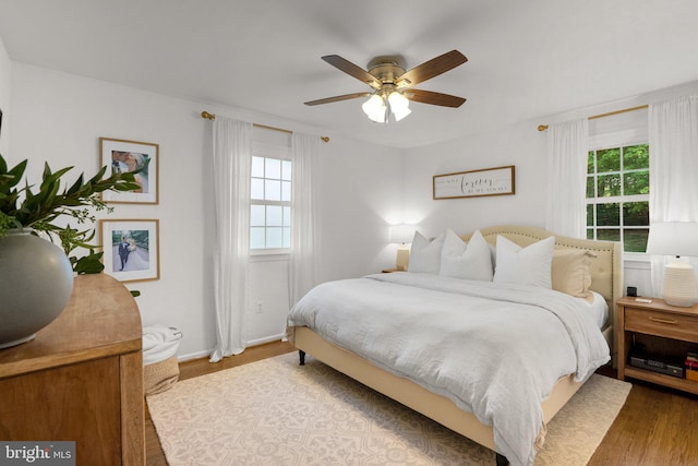 bedroom featuring baseboards, ceiling fan, and wood finished floors