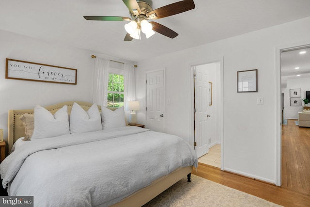 bedroom with ceiling fan, wood finished floors, baseboards, connected bathroom, and recessed lighting