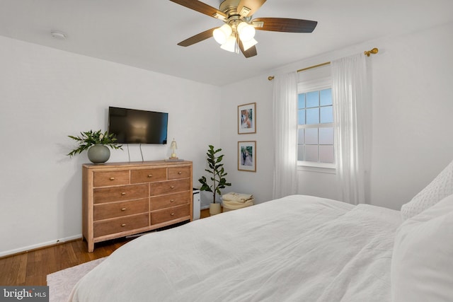 bedroom featuring baseboards, a ceiling fan, and wood finished floors