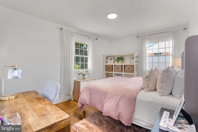 bedroom featuring wood finished floors and multiple windows