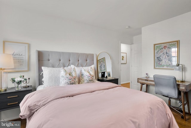 bedroom with baseboards and wood finished floors