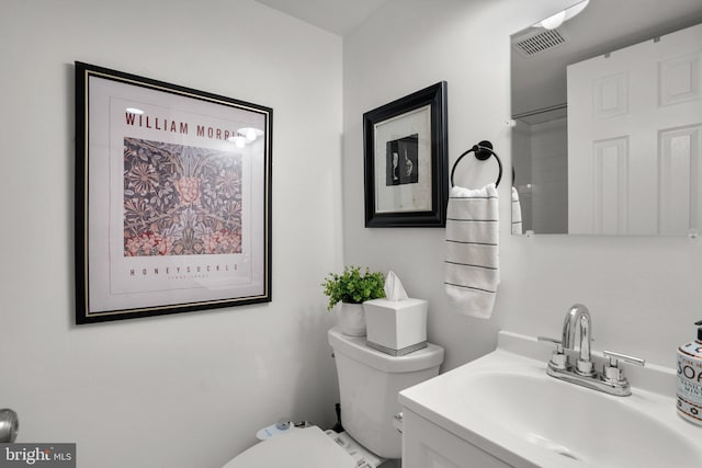 bathroom with visible vents, toilet, and vanity