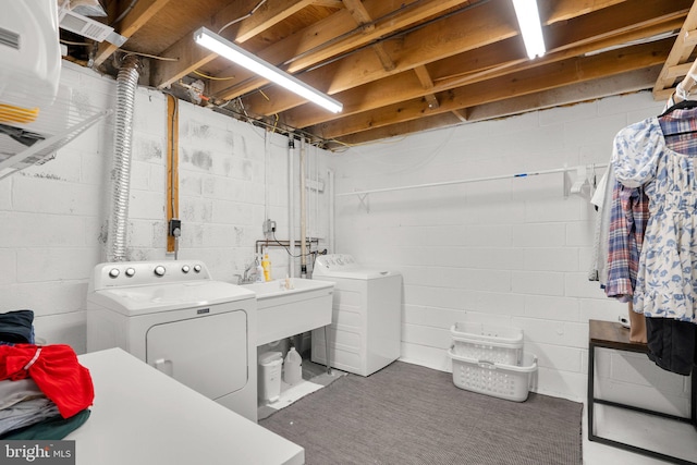 clothes washing area with washing machine and clothes dryer, laundry area, and a sink