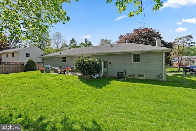 rear view of house featuring a lawn, fence, cooling unit, and a chimney
