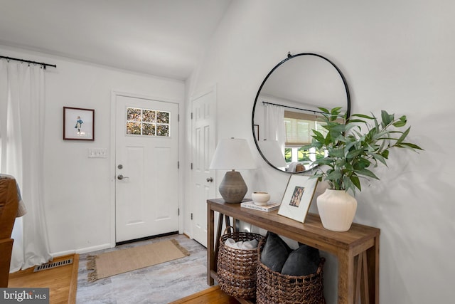 foyer entrance with baseboards and visible vents