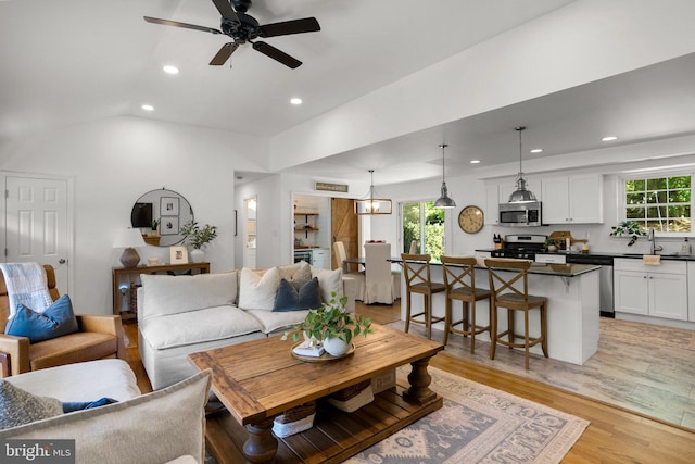 living area featuring a healthy amount of sunlight, a ceiling fan, recessed lighting, and light wood-style flooring