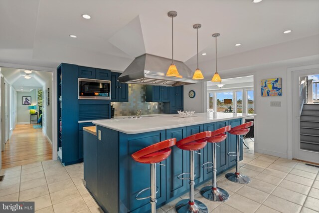 5419 Ragged Point Rd, Cambridge, MD 21613 - kitchen with blue cabinetry, stainless steel microwave, light tile patterned floors, light countertops, and recessed lighting
