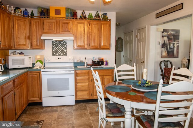 216 Laurel Ct, Pine Grove, PA 17963 - kitchen with stone finish flooring, under cabinet range hood, brown cabinets, and white appliances