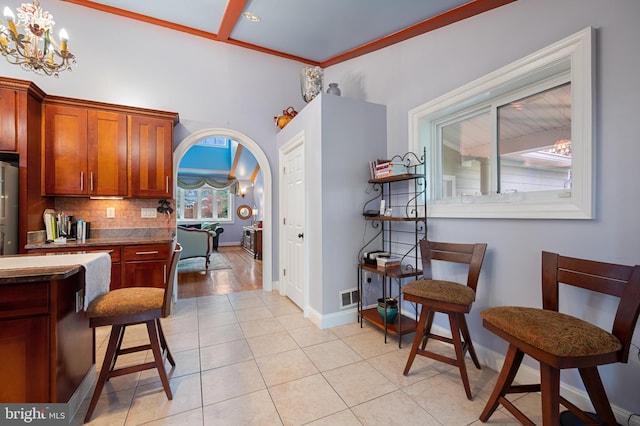 1110 Brantford Ave, Silver Spring, MD 20904 - kitchen featuring arched walkways, a chandelier, decorative backsplash, light tile patterned floors, and visible vents