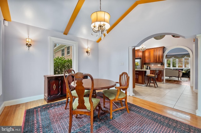 1110 Brantford Ave, Silver Spring, MD 20904 - dining room featuring arched walkways, baseboards, lofted ceiling with beams, a chandelier, and light wood-style floors