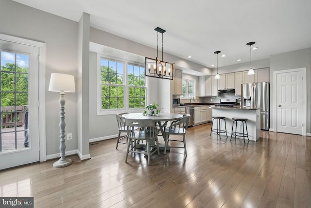 dining area featuring baseboards, a notable chandelier, and plenty of natural light