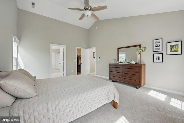 carpeted bedroom with ceiling fan, visible vents, high vaulted ceiling, baseboards, and connected bathroom