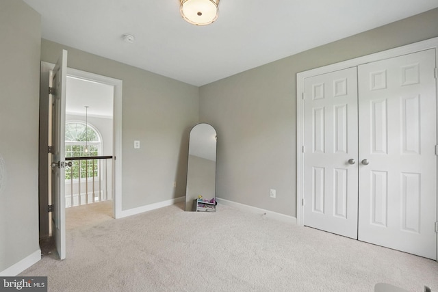 unfurnished bedroom with carpet floors, baseboards, and a closet