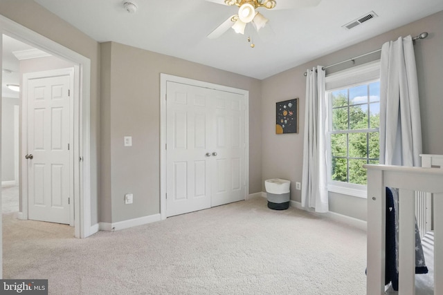 carpeted bedroom featuring a ceiling fan, baseboards, visible vents, and a closet