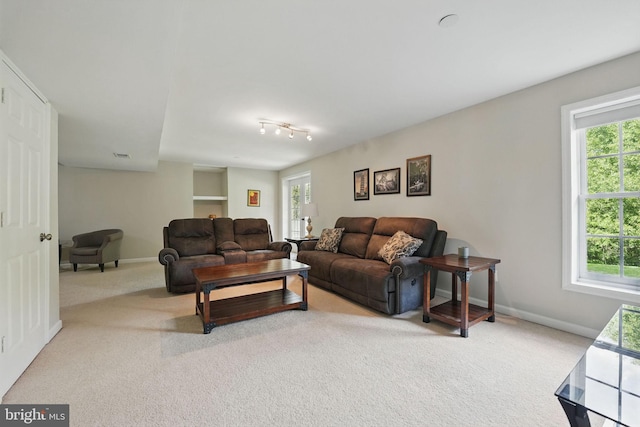 living room with carpet flooring, baseboards, and a wealth of natural light
