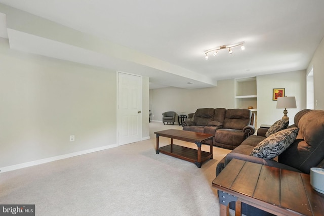 living area featuring built in features, baseboards, and carpet
