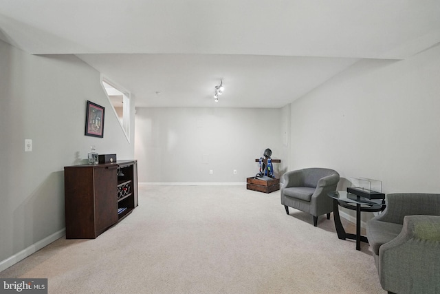living area featuring carpet flooring and baseboards