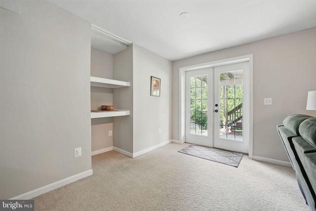 entryway with carpet floors, baseboards, built in desk, and french doors