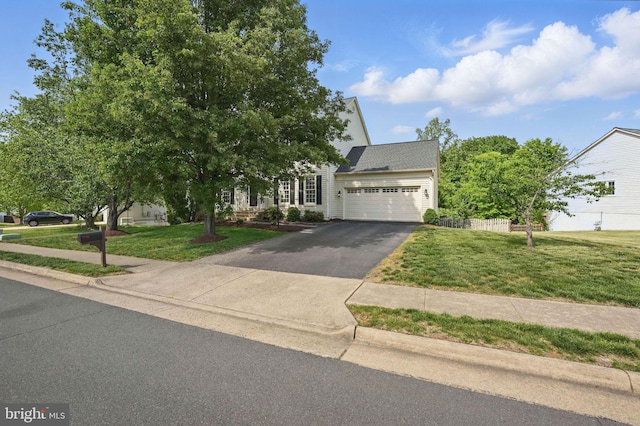 view of property hidden behind natural elements featuring a garage, a front lawn, and aphalt driveway