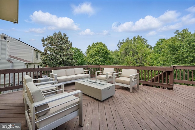 deck with an outdoor living space with a fire pit