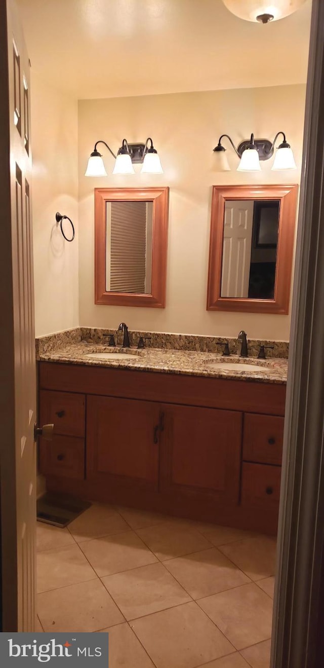 full bath featuring double vanity, tile patterned floors, and a sink