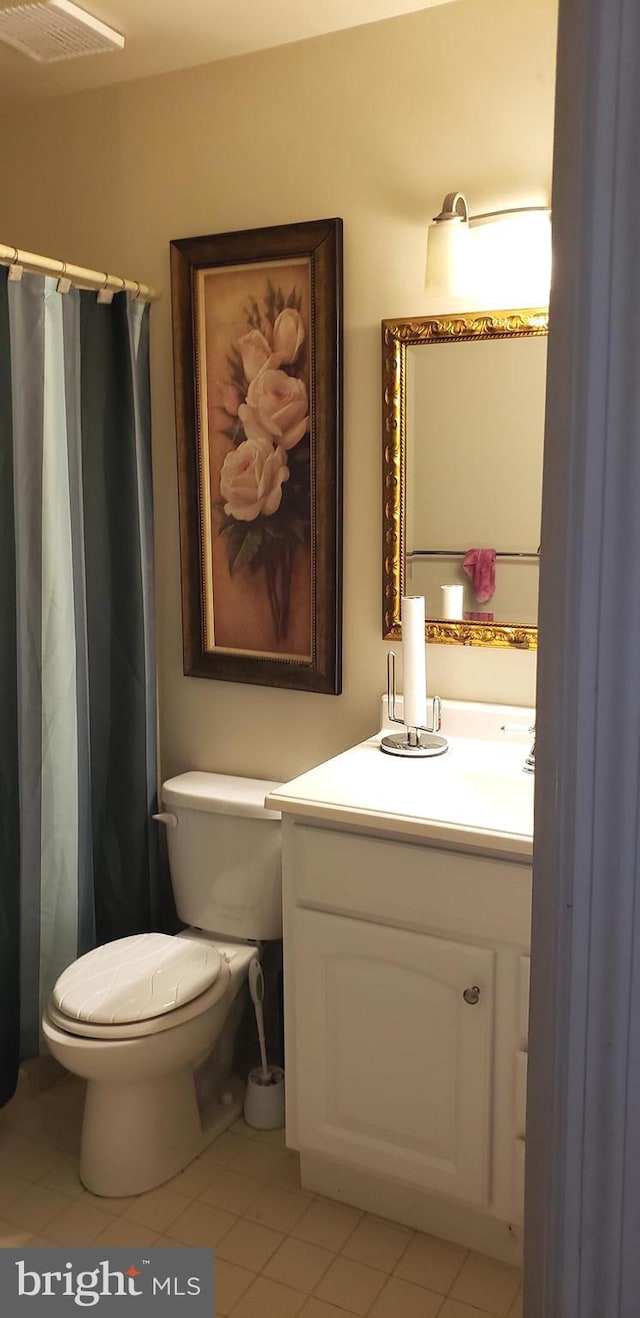 bathroom with vanity, toilet, tile patterned floors, a shower with curtain, and visible vents
