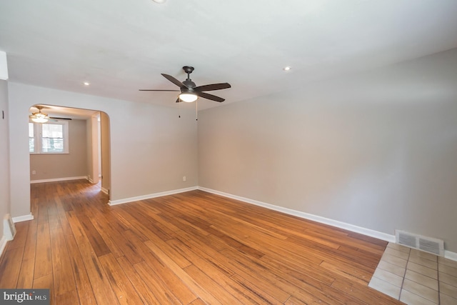 spare room with visible vents, wood-type flooring, recessed lighting, arched walkways, and a ceiling fan