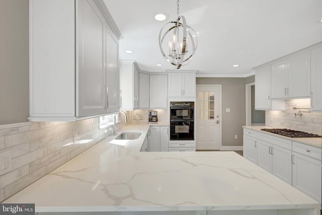kitchen featuring a sink, dobule oven black, gas cooktop, decorative backsplash, and a chandelier