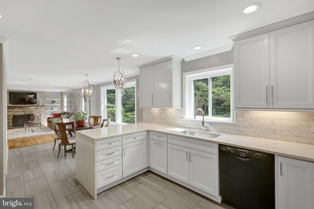 kitchen featuring a wealth of natural light, black dishwasher, a fireplace, and a sink
