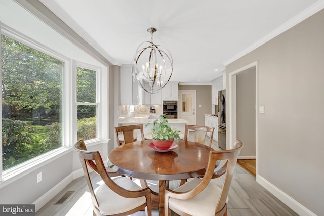 dining area with baseboards, crown molding, a chandelier, and visible vents
