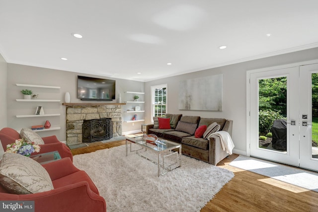 living area with a healthy amount of sunlight, wood finished floors, and ornamental molding