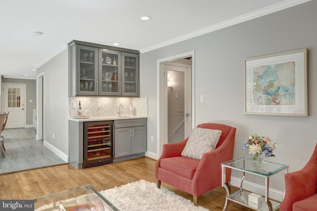 bar featuring wine cooler, recessed lighting, crown molding, and indoor wet bar