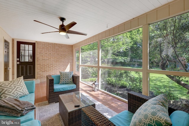 sunroom with a ceiling fan and an outdoor living space