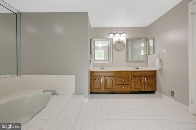 bathroom featuring a sink, baseboards, visible vents, double vanity, and a garden tub